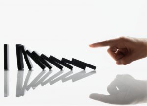 Businessman Touching Domino Pieces Arranged in a Line --- Image by Â© Royalty-Free/Corbis